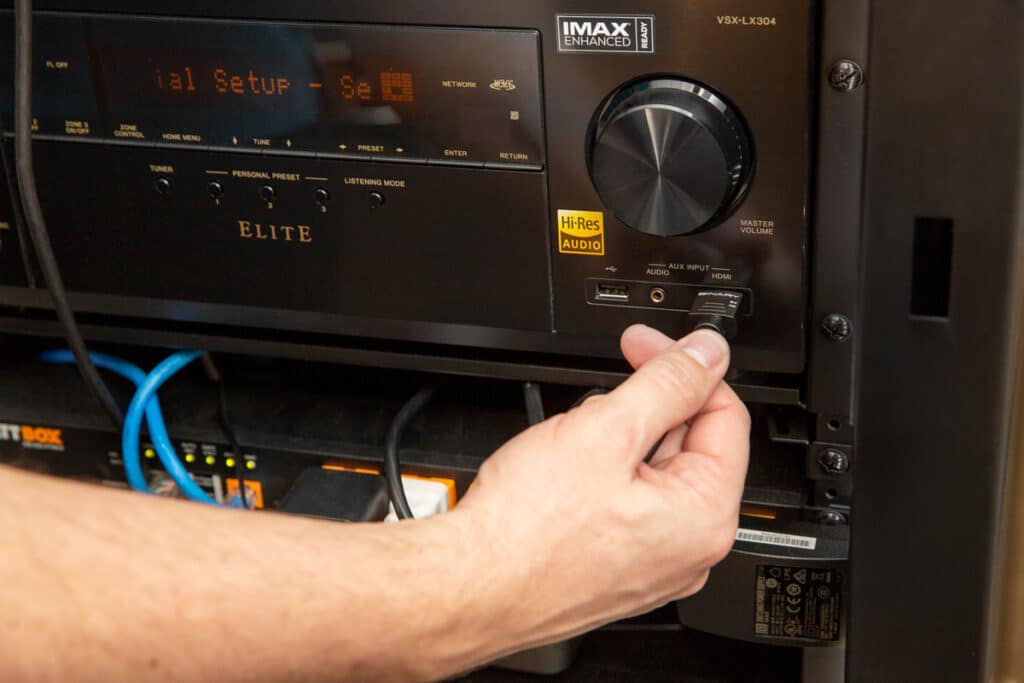 Hand connecting cable to AV receiver front input.