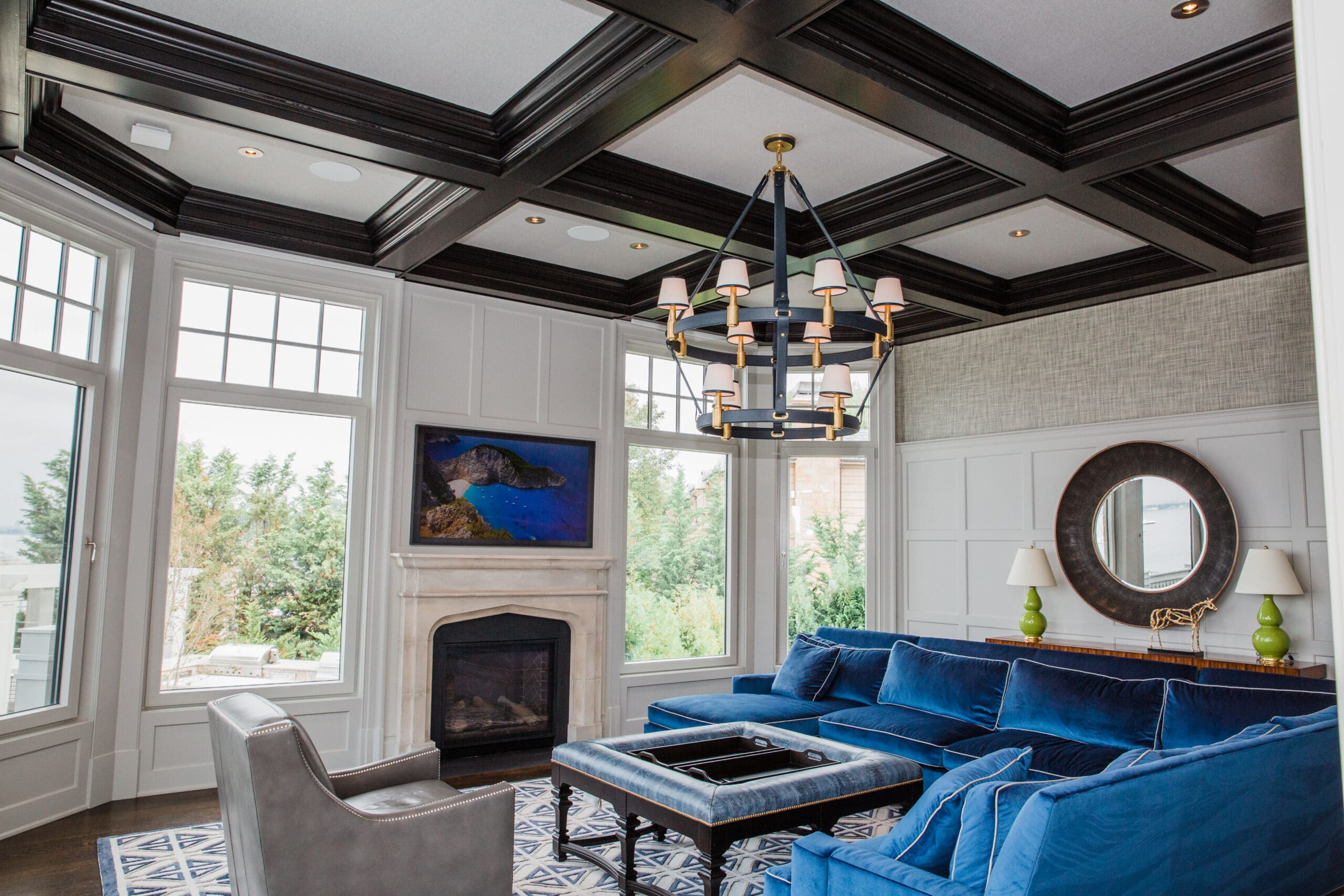 Modern living room with blue sofa and large windows.