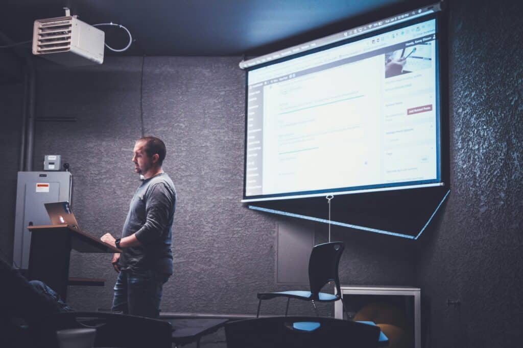 a man doing a presentation about signs you need a new projector bulb