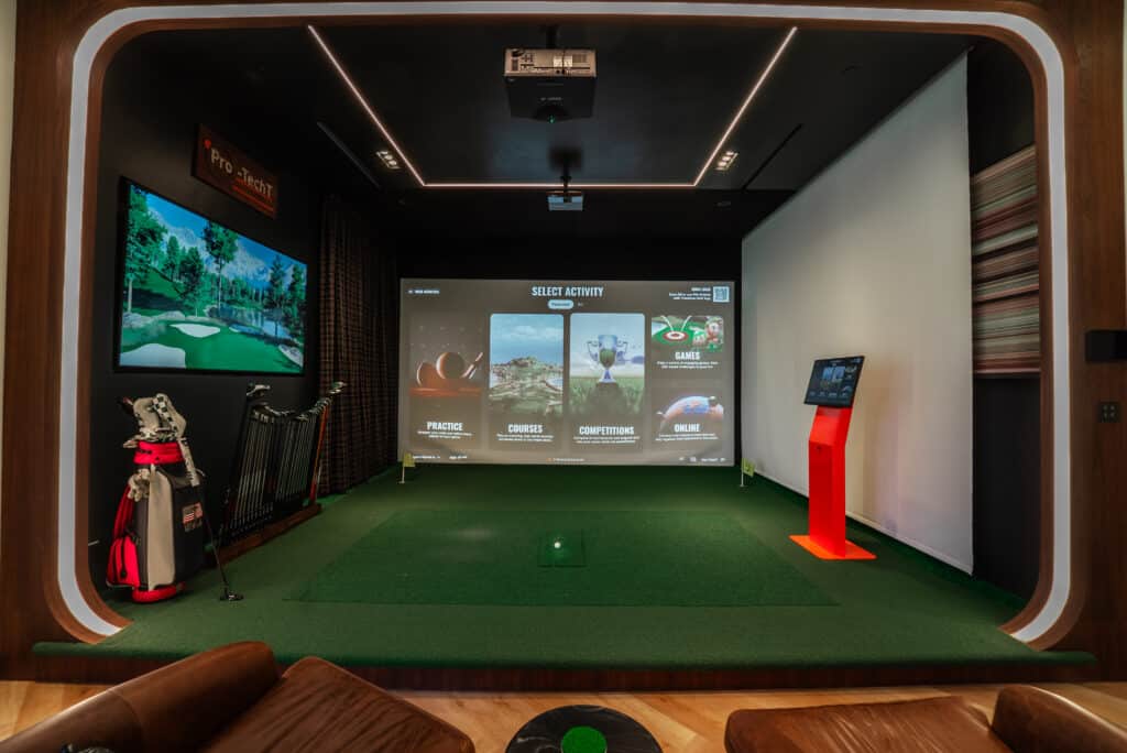 Luxury home golf simulator suite by Pro-TechT with TrackMan system, elegant seating, and integrated lighting for realistic year-round play.