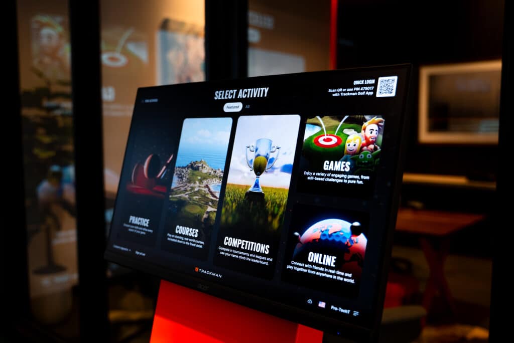 TrackMan golf simulator touchscreen showing practice, courses, competitions, and online play options in a Pro-TechT setup